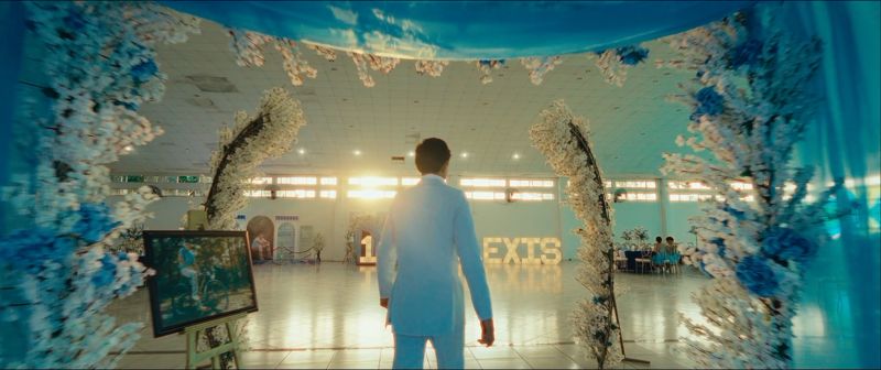Fotograma del video de XV años: el quinceañero entra al salón decorado con flores azules